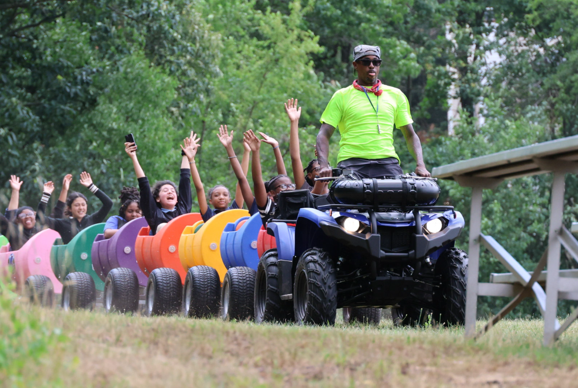 Children enjoying a colorful trackless train ride at an outdoor event